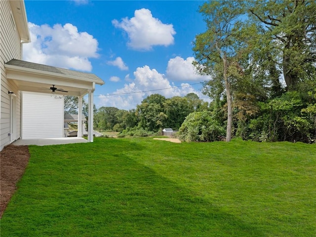 view of yard with ceiling fan and a patio