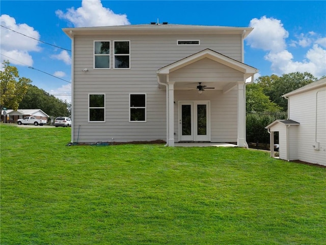 back of house featuring a lawn and ceiling fan