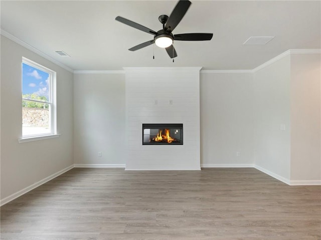 unfurnished living room with a large fireplace, light wood-type flooring, and ornamental molding