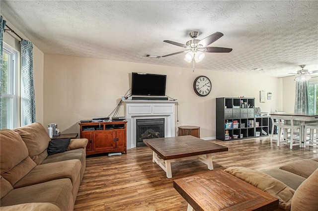 45 Ratliff Dr, Covington, GA 30016 - living area featuring ceiling fan, wood finished floors, a textured ceiling, and a fireplace