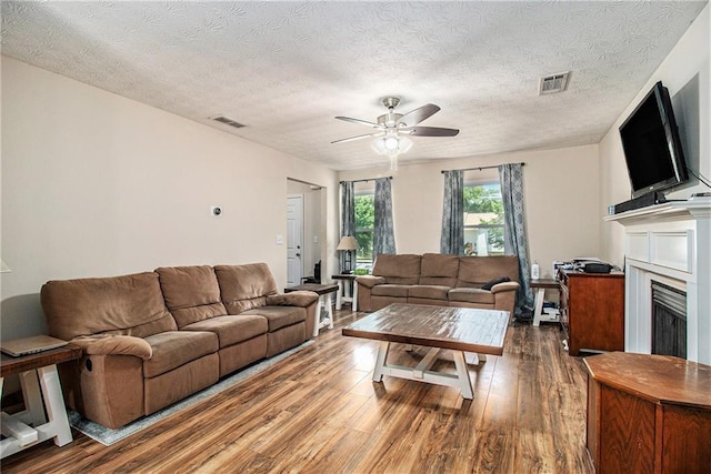 45 Ratliff Dr, Covington, GA 30016 - living room featuring a ceiling fan, wood finished floors, a fireplace, and a textured ceiling