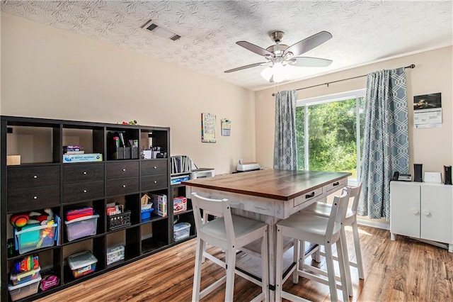 45 Ratliff Dr, Covington, GA 30016 - dining space with wood finished floors, a ceiling fan, a textured ceiling, and a desk