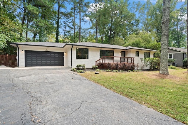 ranch-style house with an attached garage, brick siding, fence, driveway, and a front yard