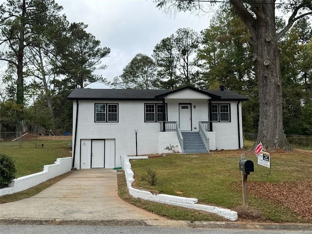 view of front facade with brick siding, a front yard, and driveway