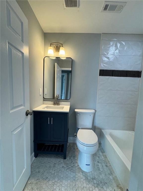 bathroom with toilet, vanity, tile patterned flooring, and baseboards
