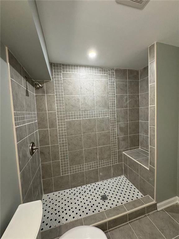 full bathroom featuring toilet, a stall shower, and tile patterned floors
