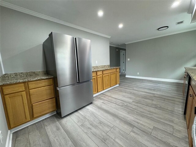 kitchen featuring freestanding refrigerator, crown molding, light wood finished floors, brown cabinets, and light stone counters