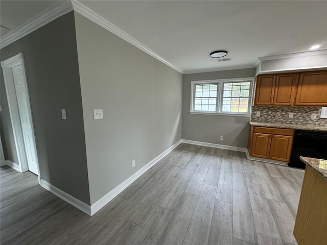 unfurnished dining area featuring light wood-style floors, baseboards, and ornamental molding