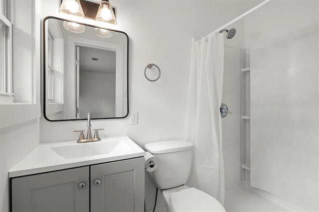 full bathroom with vanity, toilet, and a stall shower