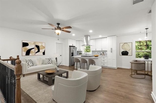 living room with visible vents, wood finished floors, recessed lighting, baseboards, and ceiling fan