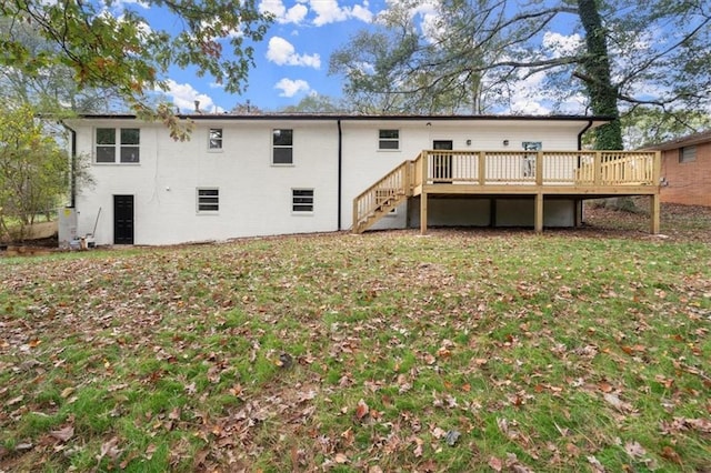 rear view of house featuring stairway, a lawn, and a wooden deck