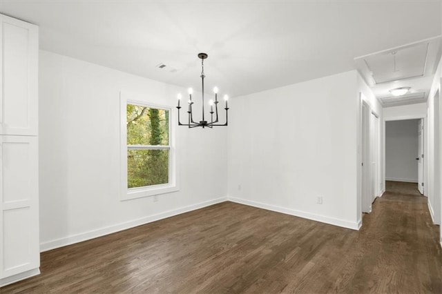 unfurnished dining area featuring visible vents, baseboards, attic access, and dark wood-style floors