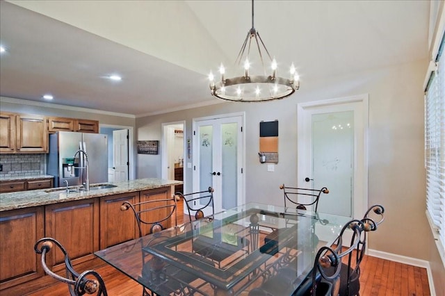 dining area with lofted ceiling, wood finished floors, recessed lighting, crown molding, and baseboards