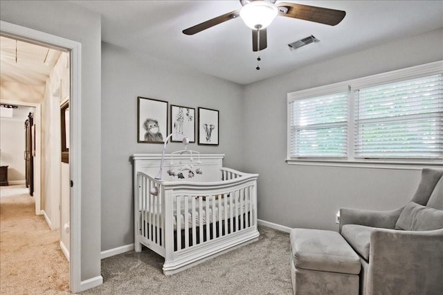 bedroom featuring visible vents, a crib, carpet floors, baseboards, and attic access