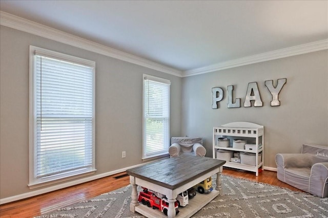 interior space with visible vents, ornamental molding, baseboards, and wood finished floors