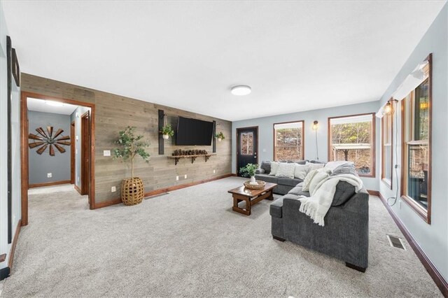 living room featuring carpet and wood walls