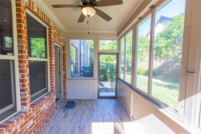 unfurnished sunroom with plenty of natural light and a ceiling fan