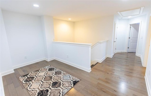 empty room with wood finished floors, baseboards, recessed lighting, and attic access