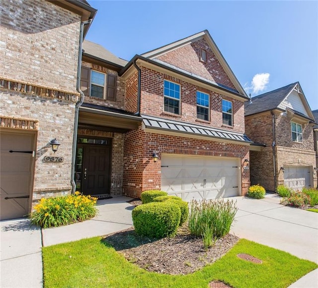 view of front of home featuring brick siding, an attached garage, and driveway