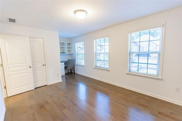 unfurnished bedroom with wood finished floors and baseboards