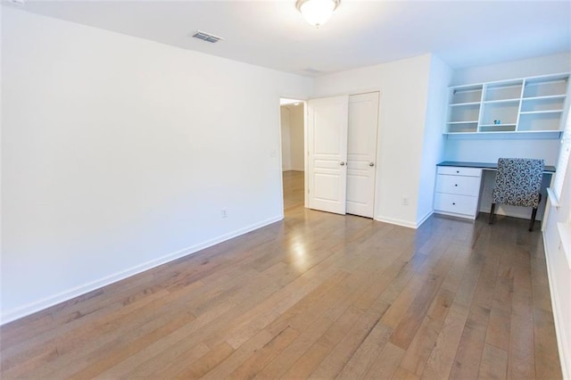 unfurnished bedroom with wood-type flooring and baseboards