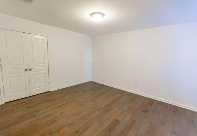 unfurnished room with wood finished floors and baseboards
