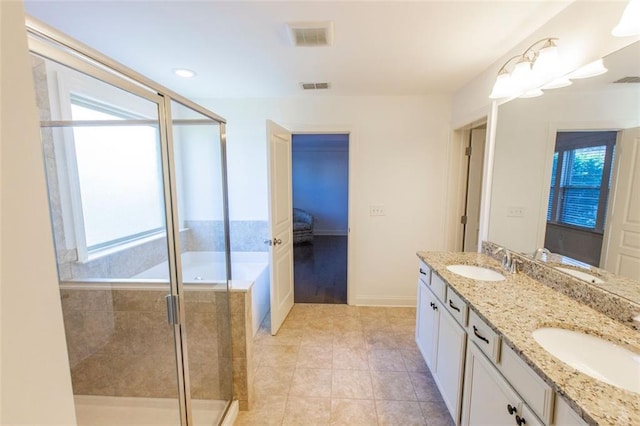 full bathroom featuring a shower stall, double vanity, ensuite bath, tile patterned flooring, and baseboards
