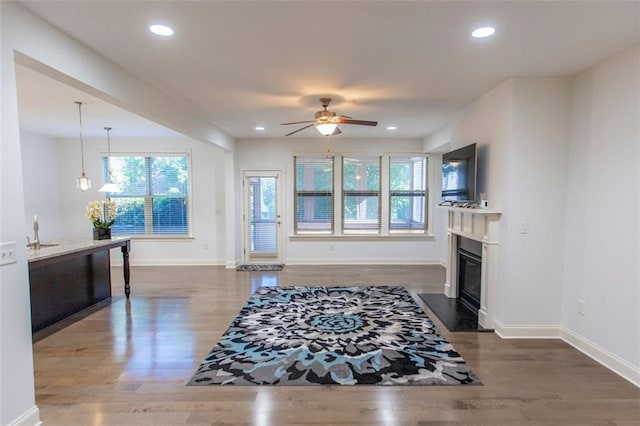 living room featuring plenty of natural light, ceiling fan, wood finished floors, baseboards, and recessed lighting