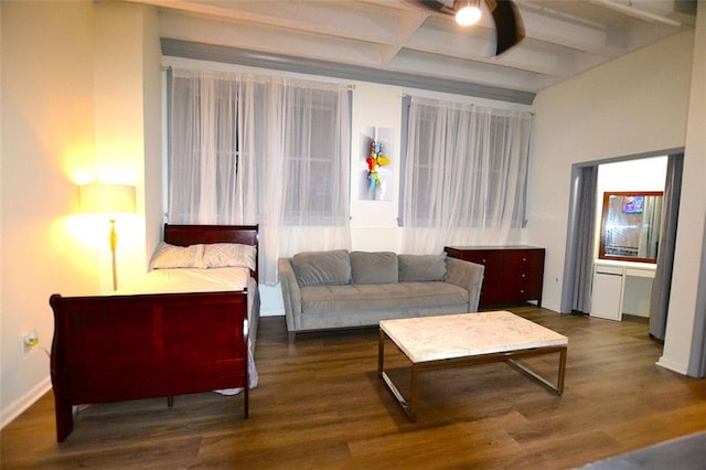 living room with ceiling fan, dark hardwood / wood-style flooring, and beamed ceiling