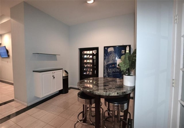 bar featuring white cabinetry and light tile patterned floors