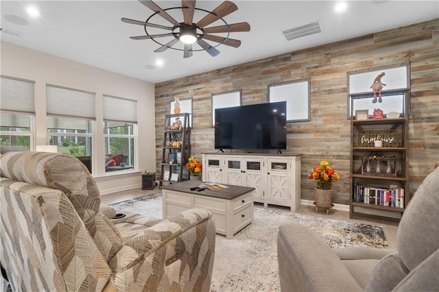 living room with wood walls and ceiling fan