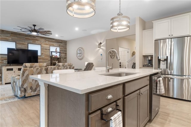 kitchen featuring ceiling fan, sink, light hardwood / wood-style flooring, white cabinetry, and stainless steel appliances