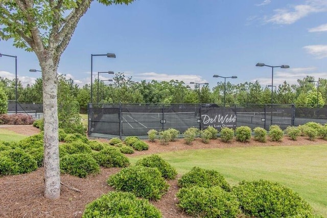 view of tennis court with a lawn