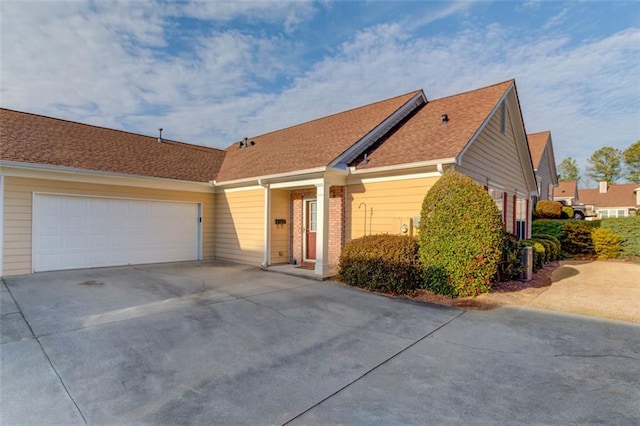 single story home featuring a garage, concrete driveway, and brick siding