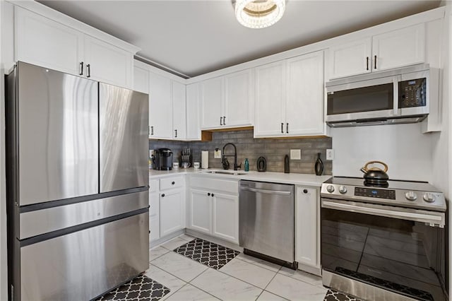 10 26th St NW Unit A2, Atlanta, GA 30309 - kitchen with a sink, marble finish floor, stainless steel appliances, light countertops, and white cabinets