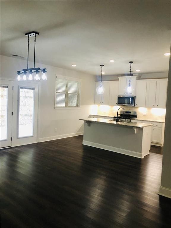 kitchen with white cabinets, dark hardwood / wood-style floors, and decorative light fixtures