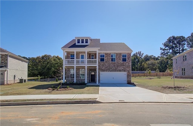 view of front of house featuring a front yard, a balcony, and a garage