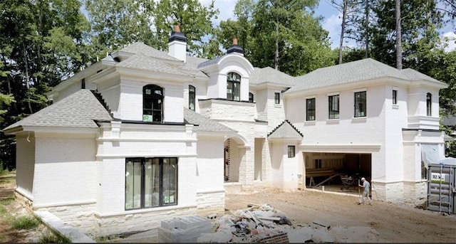 9675 Almaviva Dr, Alpharetta, GA 30022 - french country home with a chimney, an attached garage, brick siding, and a shingled roof