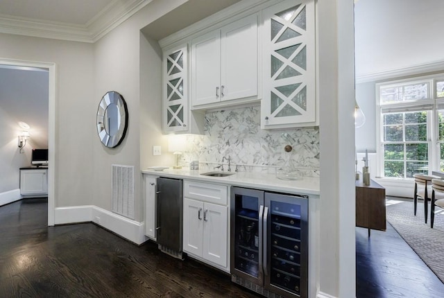 9675 Almaviva Dr, Alpharetta, GA 30022 - indoor wet bar featuring beverage cooler, dark wood finished floors, ornamental molding, decorative backsplash, and baseboards