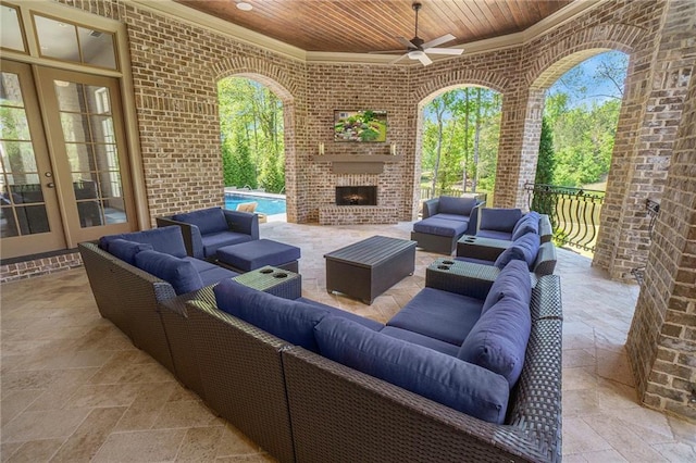 view of terrace featuring ceiling fan, french doors, and an outdoor living space with a fireplace