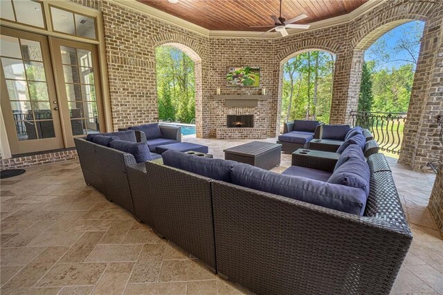 exterior space featuring ceiling fan and an outdoor living space with a fireplace