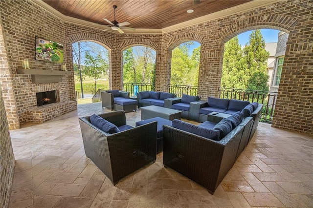 exterior space with ceiling fan and an outdoor living space with a fireplace