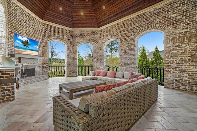 view of patio / terrace featuring exterior kitchen and an outdoor living space with a fireplace