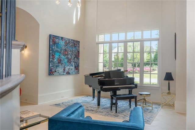 miscellaneous room featuring light tile flooring and a high ceiling