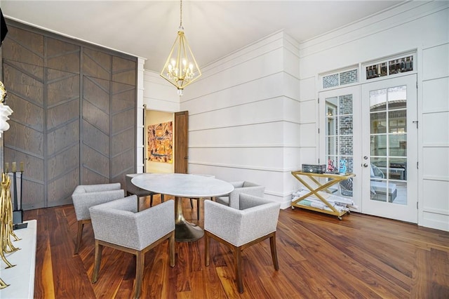 dining area featuring crown molding, french doors, dark hardwood / wood-style flooring, and a chandelier