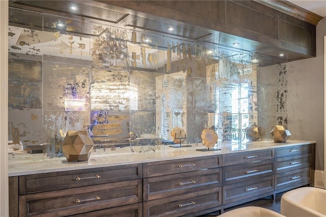 bar featuring light stone counters and dark brown cabinetry