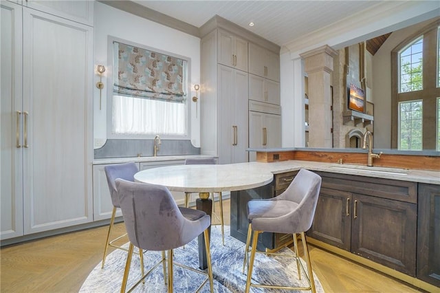 dining area featuring light parquet floors, sink, and a fireplace