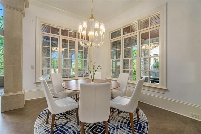 dining space with a chandelier, dark parquet flooring, ornamental molding, and decorative columns