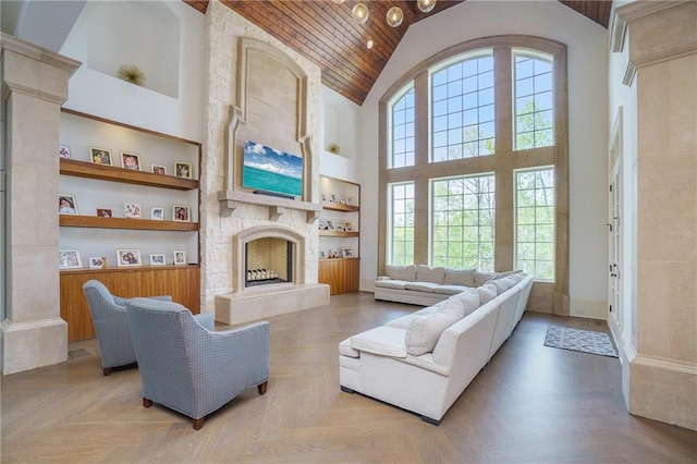 living room featuring light parquet flooring, a stone fireplace, high vaulted ceiling, and built in shelves