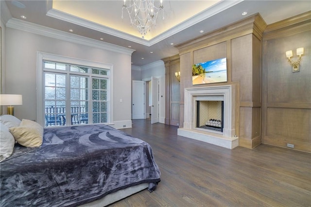 bedroom featuring dark hardwood / wood-style flooring, a notable chandelier, crown molding, and a raised ceiling